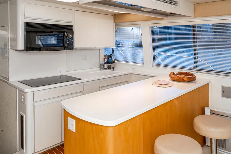 Slide: The Image of Interior of 1990 Hatteras 58 Sportfish yacht kitchen with modern appliances and seating. - 31