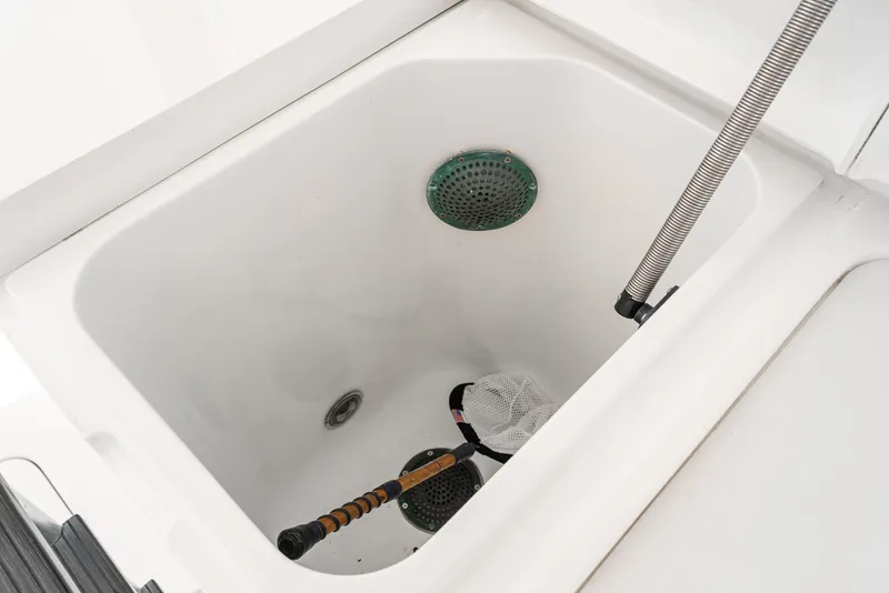 Slide: The Image of Livewell compartment on a 1990 Hatteras 58 Sportfish boat, featuring fishing equipment. - 32