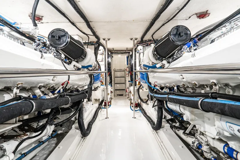 Slide: The Image of Engine room of 1990 Hatteras 58 Sportfish yacht, showcasing dual engines and clean layout. - 34