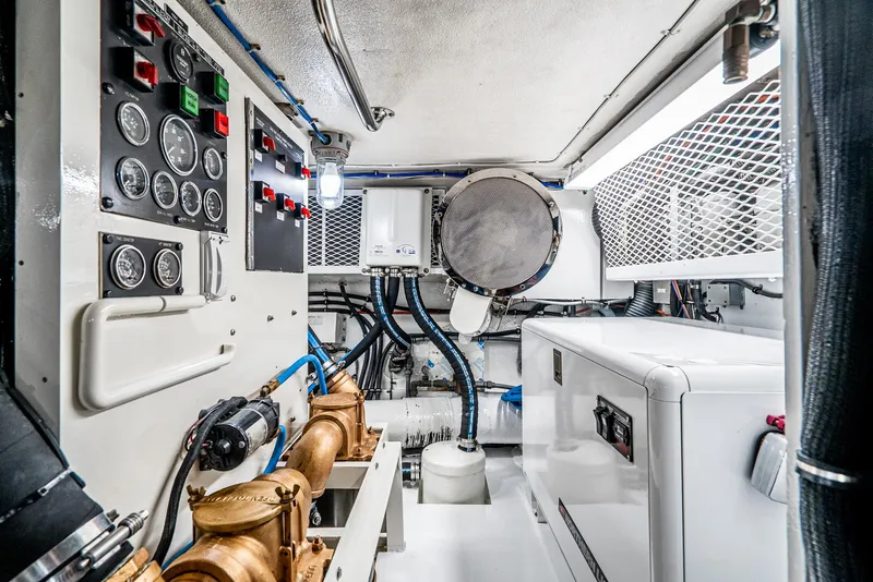 Slide: The Image of Engine room of 1990 Hatteras 58 Sportfish with control panels and machinery. - 36