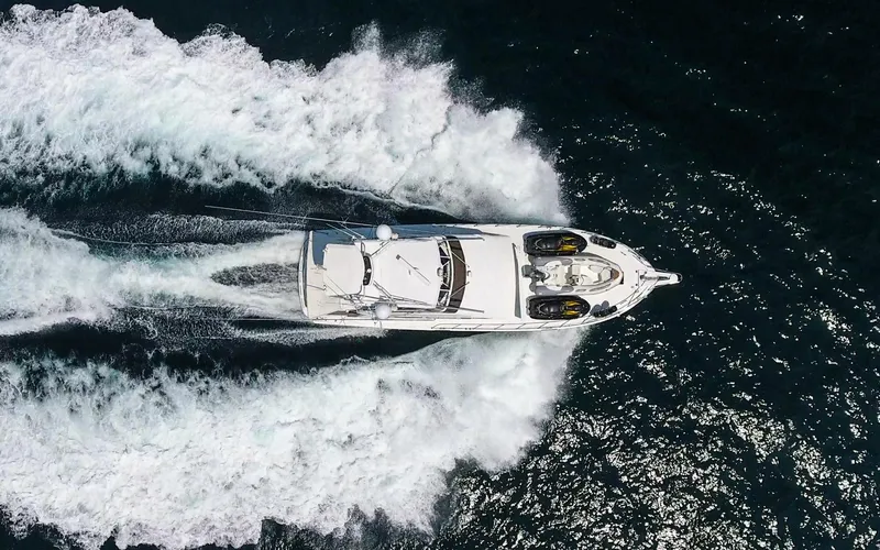 Slide: The Image of Aerial view of 1990 Hatteras 58 Sportfish yacht cruising on open water. - 4