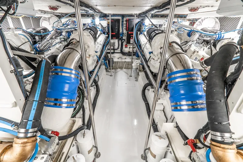 Slide: The Image of Engine room of a 1990 Hatteras 58 Sportfish, featuring dual engines and blue accents. - 44