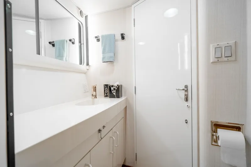 Slide: The Image of Bathroom interior of 1990 Hatteras 58 Sportfish yacht, featuring modern fixtures and white cabinetry. - 46