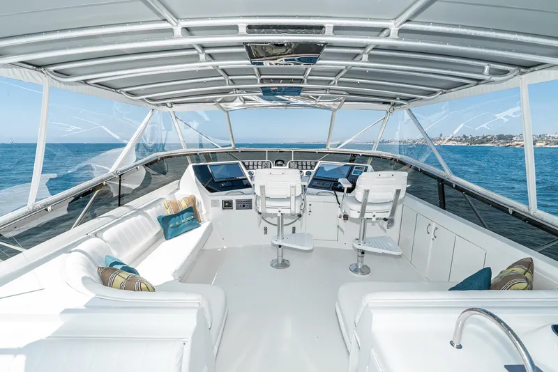 Slide: The Image of 1990 Hatteras 58 Sportfish yacht interior with helm, seating, and ocean view. - 8