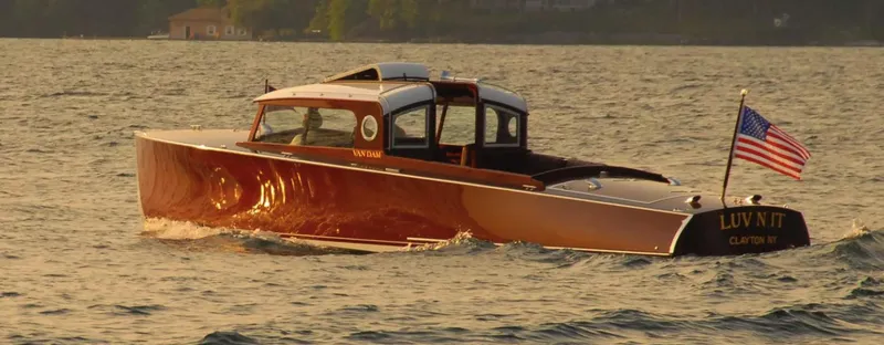 Slide: The Image of Van Dam 35 boat from 2015 on a lake, American flag waving. - 2