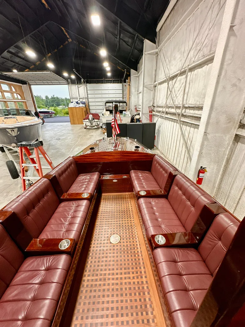 Slide: The Image of Luxurious 2015 Van Dam 35 boat with elegant maroon seating in a spacious garage. - 20