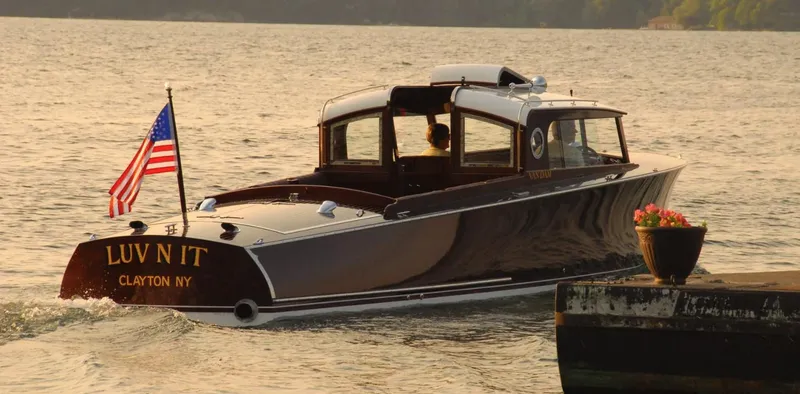 Slide: The Image of Elegant 2015 Van Dam 35 boat on water, American flag, dockside flowers, sunset backdrop. - 3