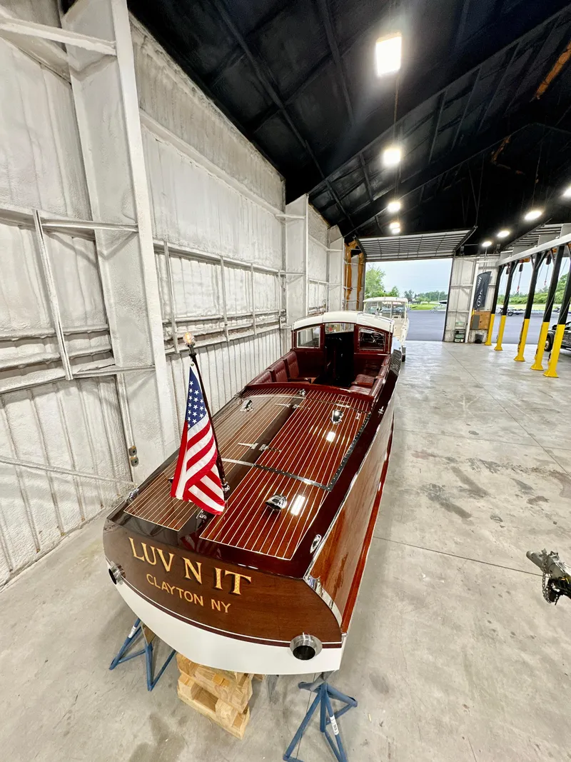 Slide: The Image of Van Dam 35 boat, 2015 model, in a warehouse with American flag, named "Luv N It". - 7