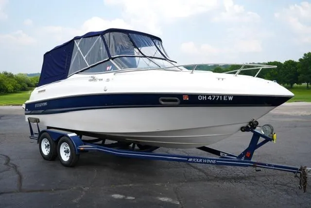 The Image of 2002 Four Winns 225 Sundowner boat on trailer, parked outdoors. - 1