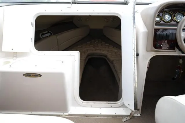 Slide: The Image of 2002 Four Winns 225 Sundowner cabin interior with seating and dashboard view. - 10
