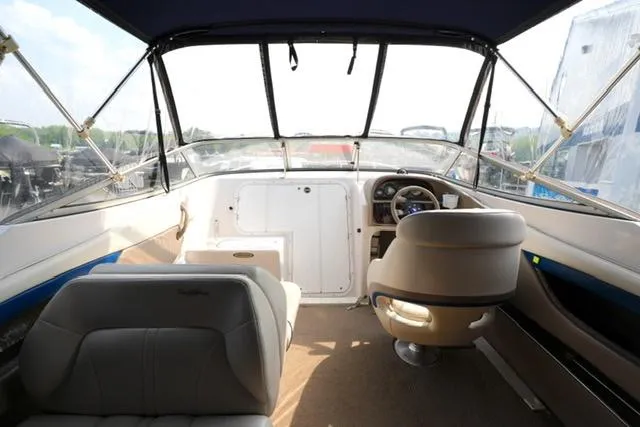Slide: The Image of Interior view of 2002 Four Winns 225 Sundowner boat cockpit with seating and steering wheel. - 7