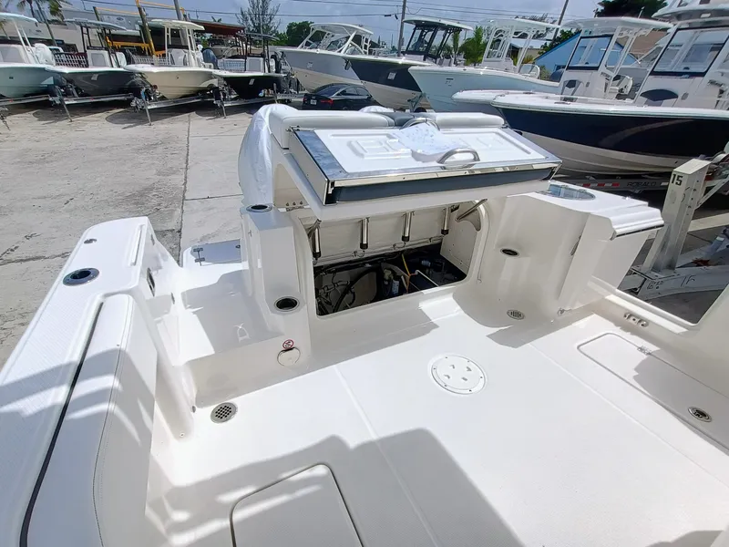 Slide: The Image of 2025 Robalo R270 Center Console boat interior with open storage compartment, docked among other boats. - 10