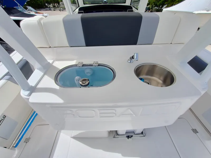 Slide: The Image of 2025 Robalo R270 Center Console boat interior with sink and storage compartments. - 12