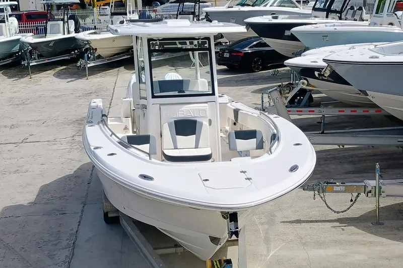 Slide: The Image of 2025 Robalo R270 Center Console boat on trailer in marina setting. - 2