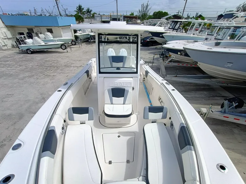 Slide: The Image of 2025 Robalo R270 Center Console boat with spacious seating, docked in a marina. - 3