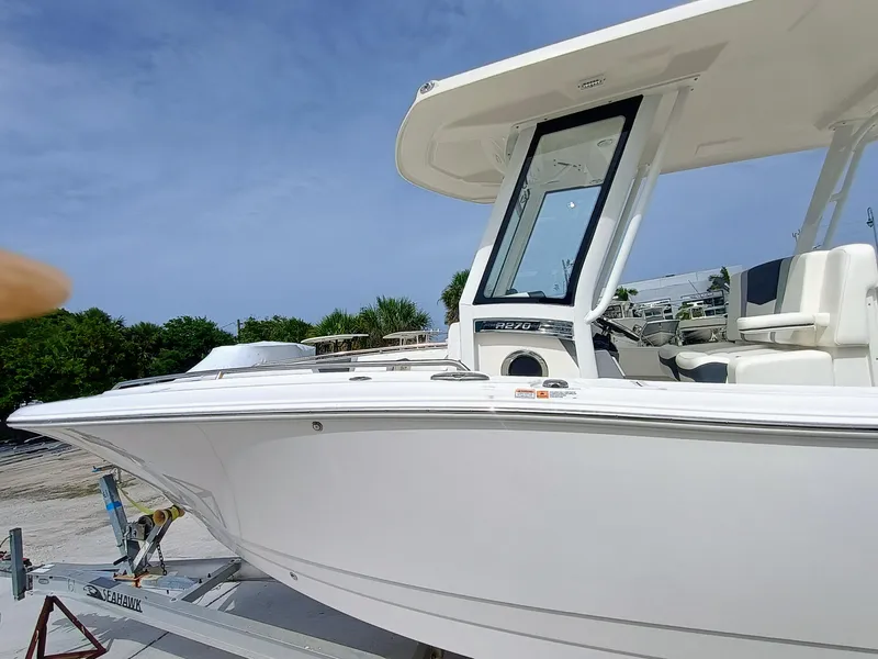 Slide: The Image of 2025 Robalo R270 Center Console boat on trailer, side view under clear sky. - 34