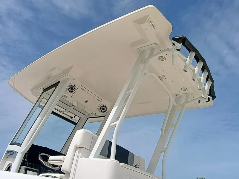 Slide: The Image of 2025 Robalo R270 Center Console boat, featuring a sleek T-top design against a clear blue sky. - 35