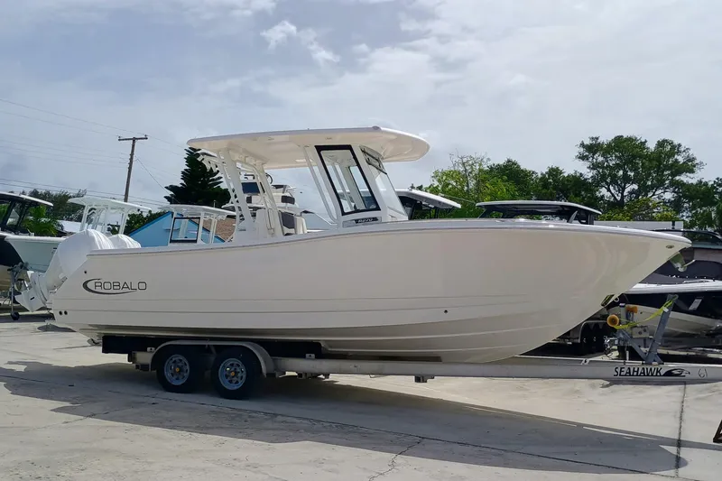 Slide: The Image of 2025 Robalo R270 Center Console boat on trailer, parked outdoors. - 5