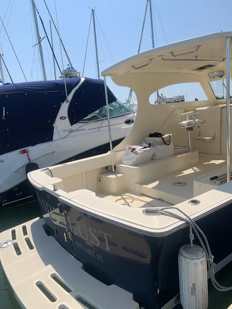 Slide: The Image of 2004 Mainship Pilot 30-II Sedan docked at marina, featuring spacious deck and sleek design. - 22