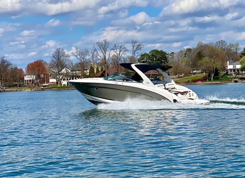 The Image of 2016 Regal 3200 Bowrider cruising on a scenic lake under a partly cloudy sky. - 0