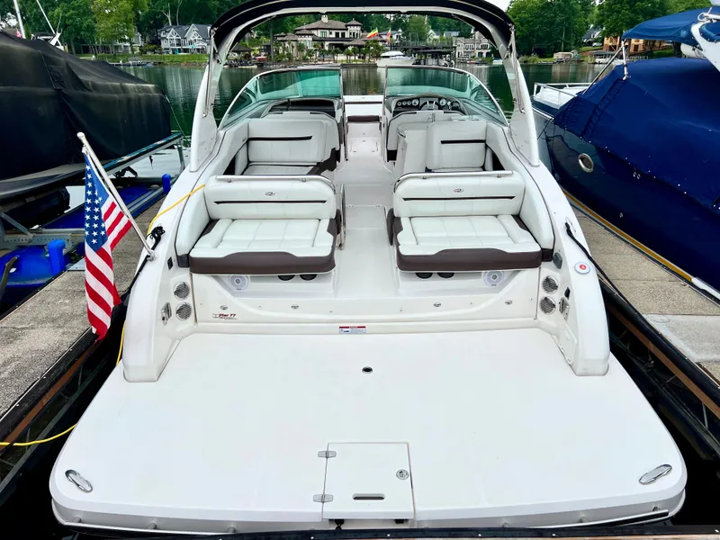 Slide: The Image of 2016 Regal 3200 Bowrider boat docked, featuring spacious seating and American flag. - 2