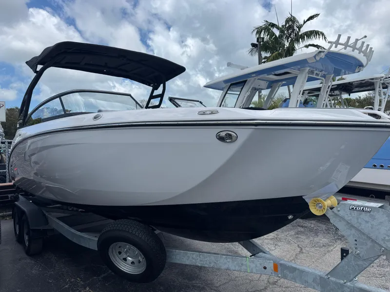 Slide: The Image of 2025 Yamaha Boats 252SD on trailer, sleek design, under cloudy sky. - 1