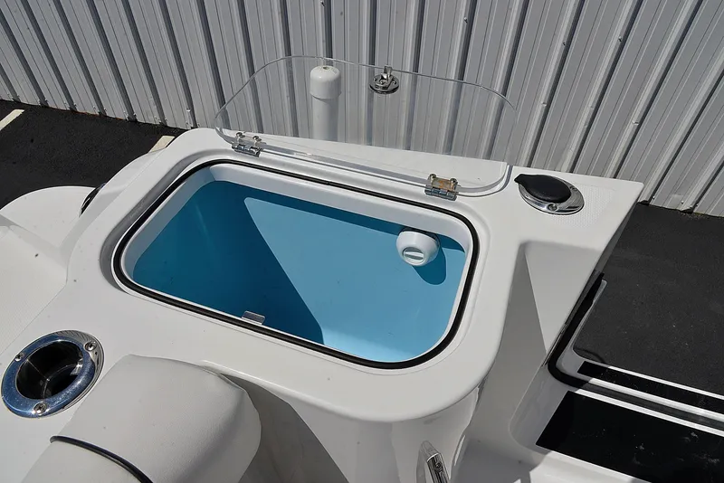 Slide: The Image of 2021 Wellcraft 262 Fisherman boat livewell with blue interior, located near a metal wall. - 14
