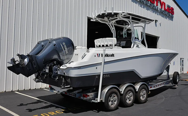 Slide: The Image of 2021 Wellcraft 262 Fisherman boat on trailer, parked outside a large building. - 3