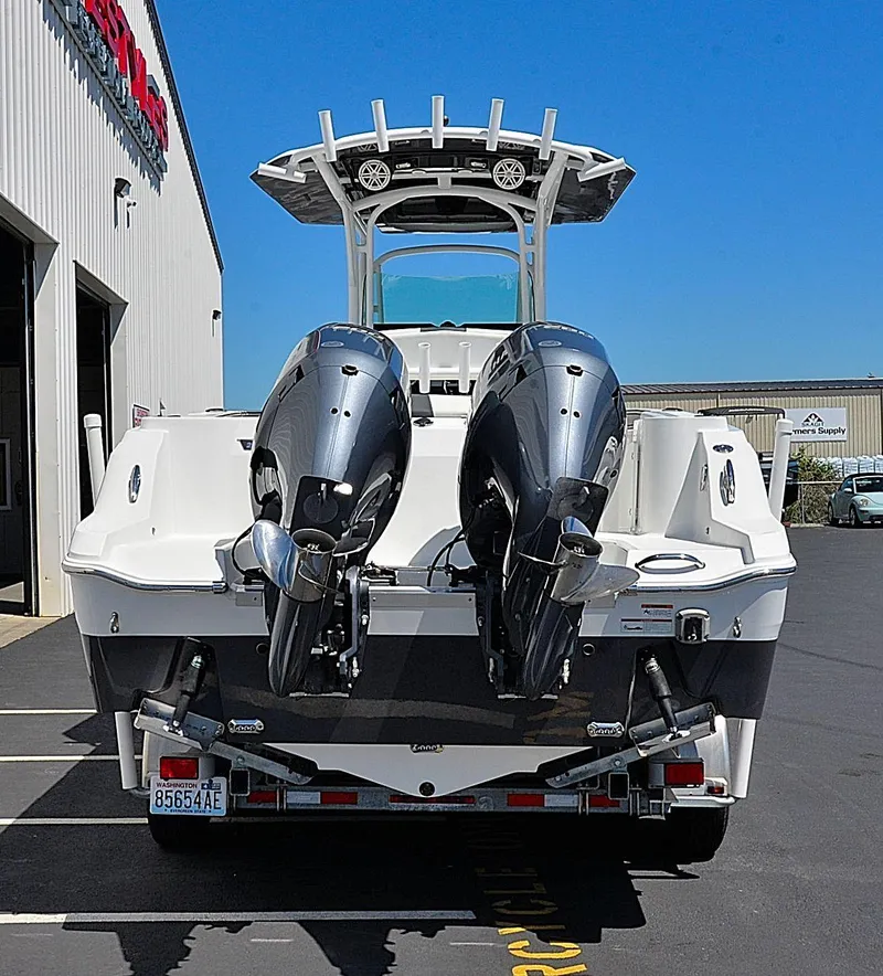Slide: The Image of 2021 Wellcraft 262 Fisherman boat with dual outboard engines, parked outside a building. - 5