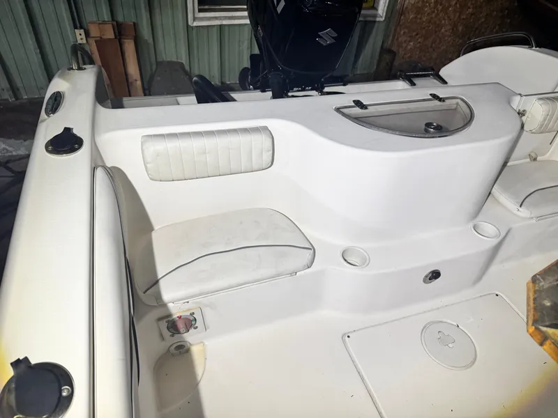 Slide: The Image of 2012 Carolina Skiff Sea Chaser 2400 Offshore boat interior with white seating and storage compartments. - 21