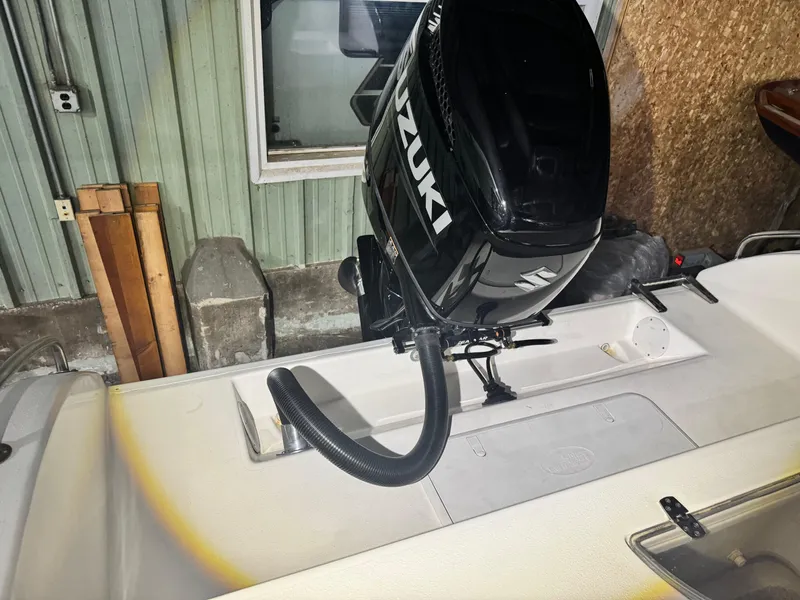 Slide: The Image of 2012 Carolina Skiff Sea Chaser 2400 Offshore with Suzuki outboard motor in a garage. - 26