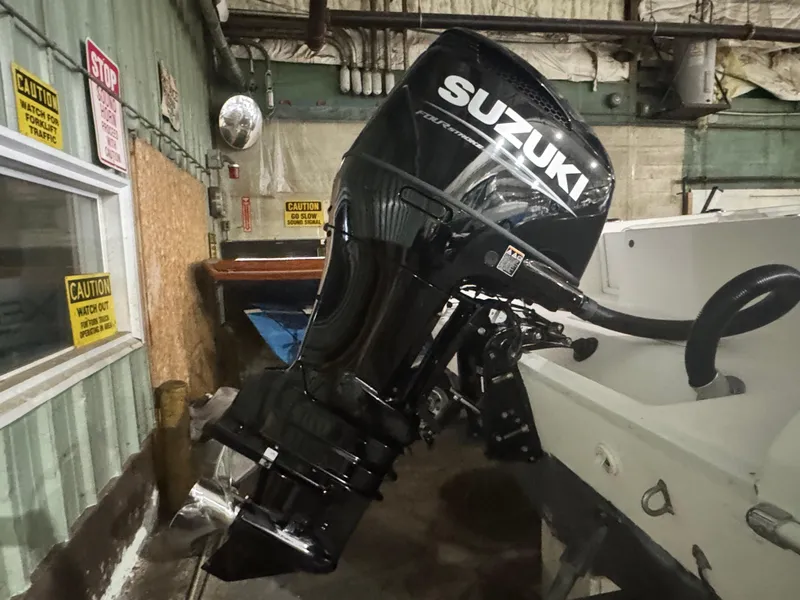 Slide: The Image of 2012 Carolina Skiff Sea Chaser 2400 Offshore with Suzuki outboard motor in a workshop. - 6