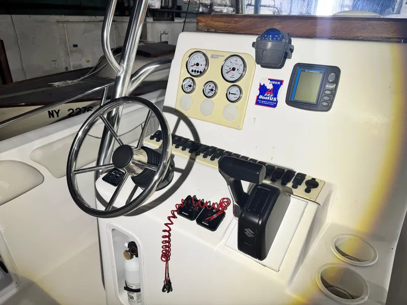 Slide: The Image of 2012 Carolina Skiff Sea Chaser 2400 Offshore boat dashboard with steering wheel and controls. - 9