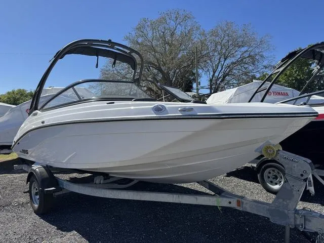 Slide: The Image of 2025 Yamaha Boats AR195 on trailer, sleek design, parked outdoors under clear blue sky. - 2