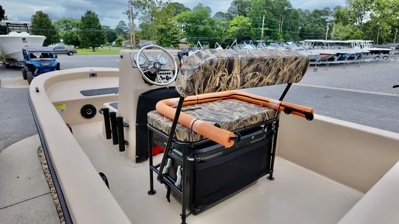 Slide: The Image of 2025 Carolina Skiff E18 JVX Swamp Edition boat with camo seating and steering console. - 5