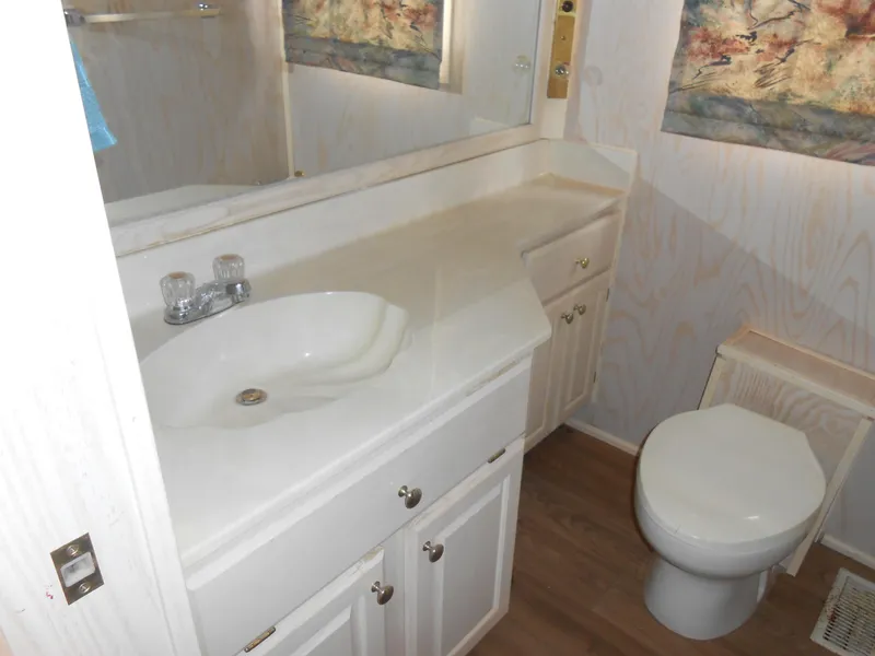 Slide: The Image of Bathroom interior of a 1994 Stardust Cruisers houseboat with white cabinetry and sink. - 14