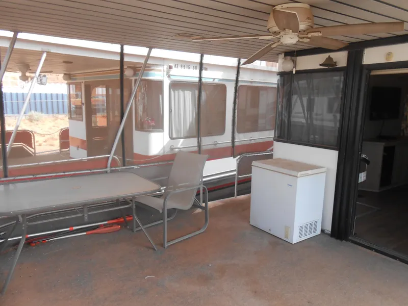 Slide: The Image of 1994 Stardust Cruisers houseboat interior with table, chair, and ceiling fan. - 2