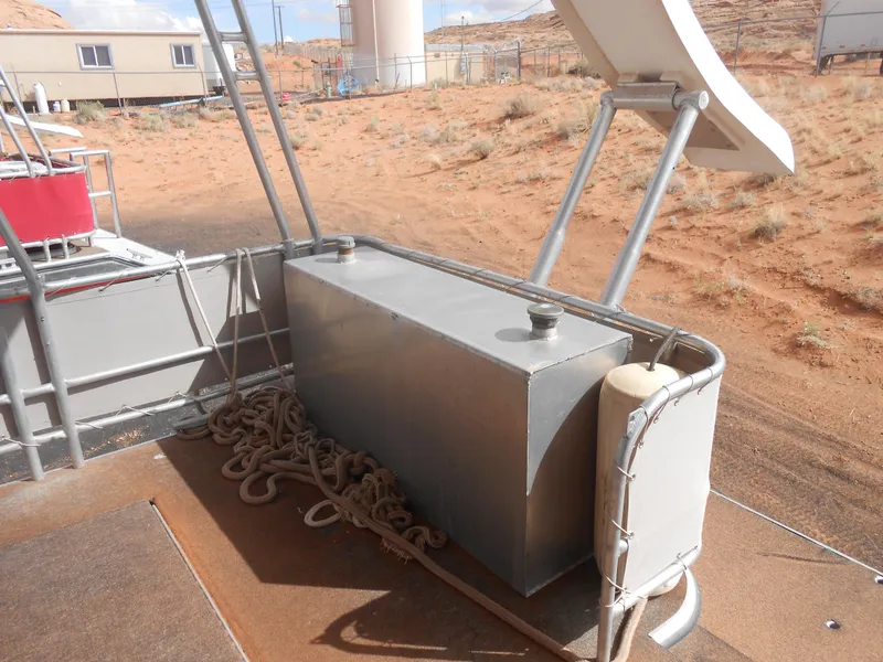 Slide: The Image of 1994 Stardust Cruisers houseboat deck with storage box and ropes, set in a desert landscape. - 23