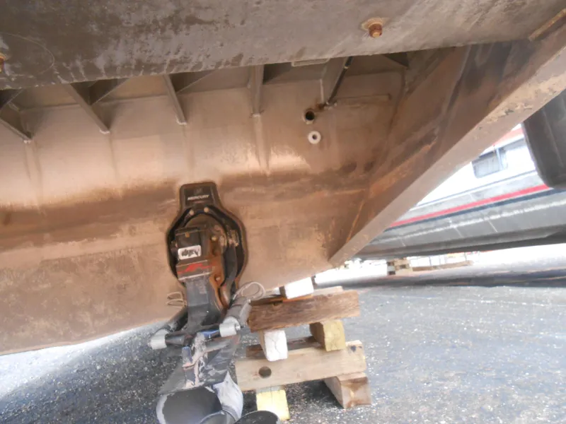 Slide: The Image of 1994 Stardust Cruisers houseboat underside on blocks, showing hull and propeller area. - 25