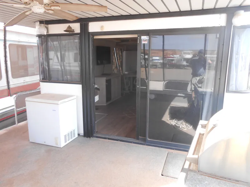 Slide: The Image of 1994 Stardust Cruisers houseboat with sliding glass doors, ceiling fan, and outdoor seating area. - 3