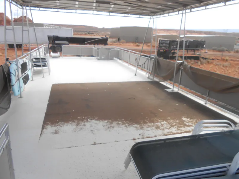 Slide: The Image of 1994 Stardust Cruisers houseboat deck with lounge chairs, canopy, and desert background. - 35