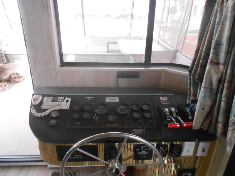 Slide: The Image of 1994 Stardust Cruisers houseboat helm with steering wheel and control panel. - 5