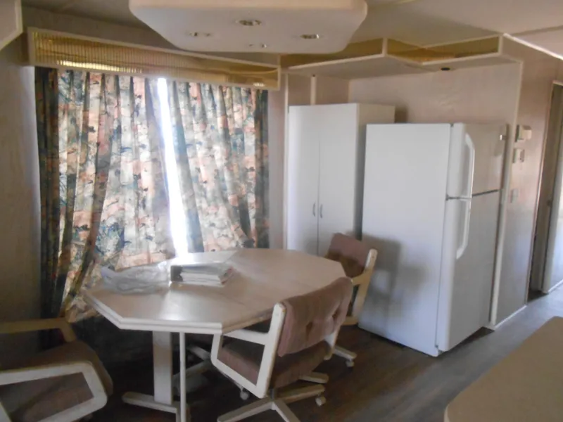Slide: The Image of 1994 Stardust Cruisers houseboat interior with dining area and kitchen appliances. - 9