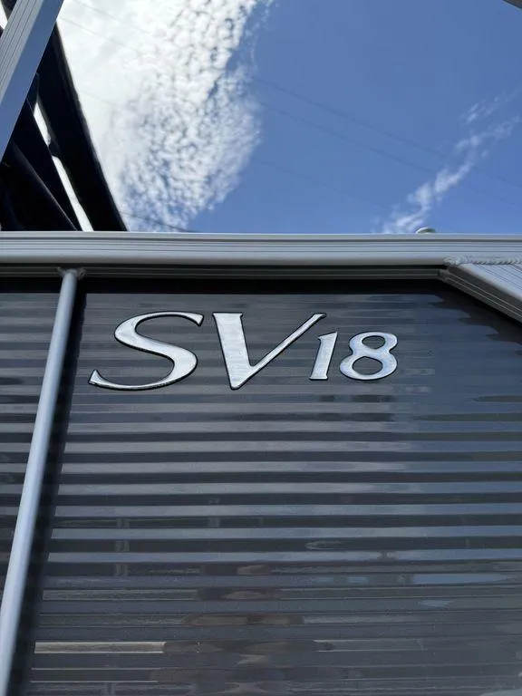 Slide: The Image of 2025 Bennington S L-Bench 18SVL boat exterior with SV18 emblem under blue sky. - 11
