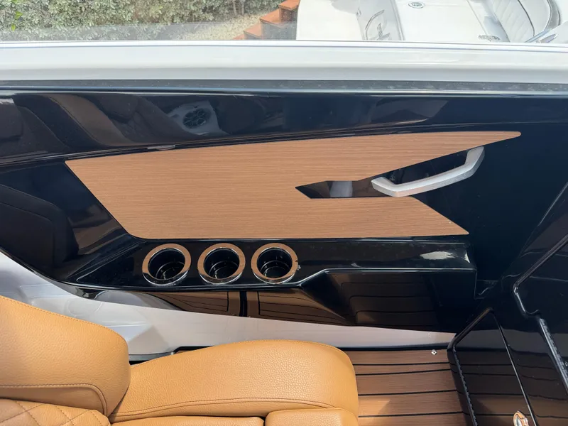 Slide: The Image of 2025 Yamaha Boats 222S interior detail with tan leather and sleek black accents. - 11