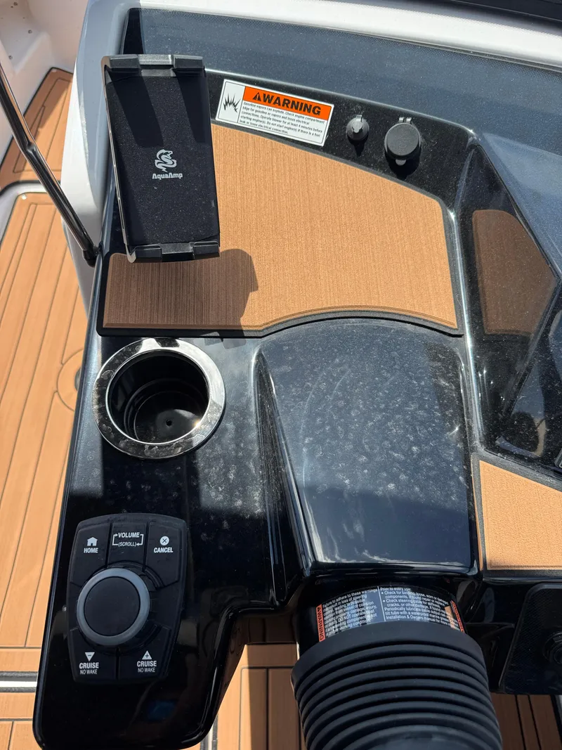 Slide: The Image of Control panel of 2025 Yamaha Boats 222S with cup holder and warning label. - 20