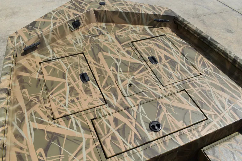 Slide: The Image of 2025 Lowe RX1860 Tunnel Jet boat deck with camouflage pattern and storage compartments. - 11