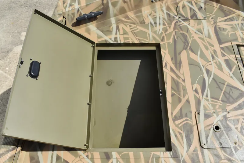 Slide: The Image of Open storage compartment on 2025 Lowe RX1860 Tunnel Jet boat with camouflage design. - 13