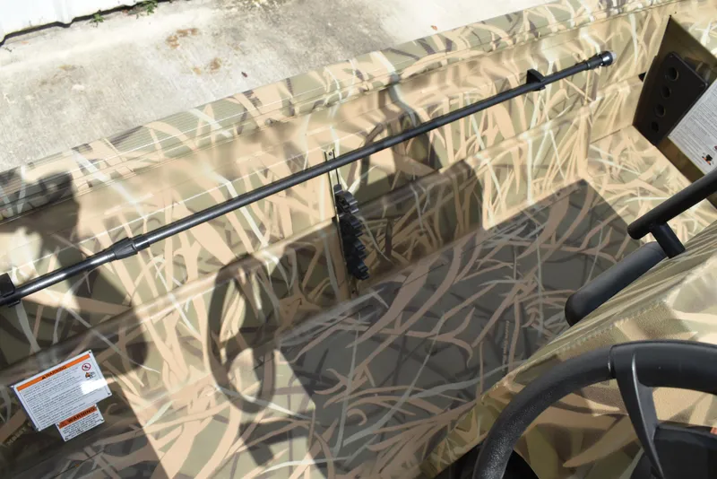 Slide: The Image of 2025 Lowe RX1860 Tunnel Jet boat interior with camouflage design and steering wheel. - 19