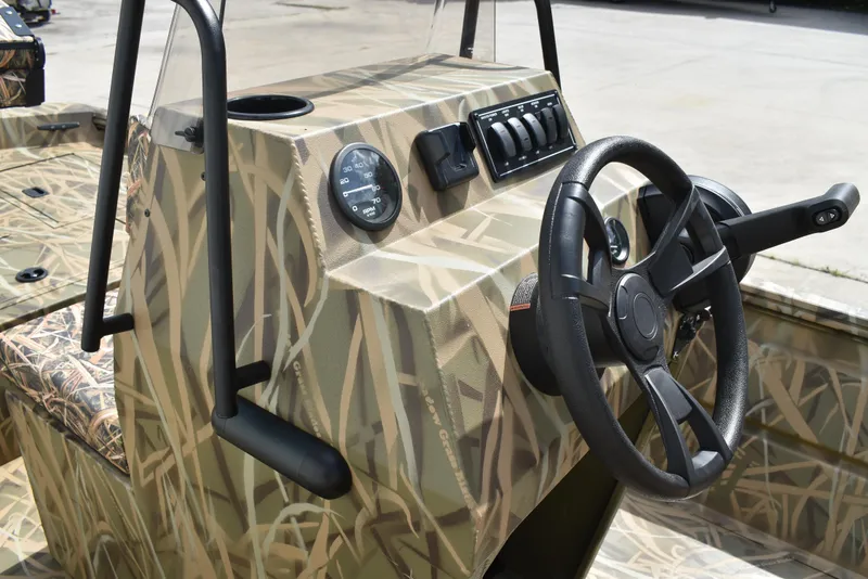 Slide: The Image of Camouflage interior of 2025 Lowe RX1860 Tunnel Jet boat with steering wheel and controls. - 21